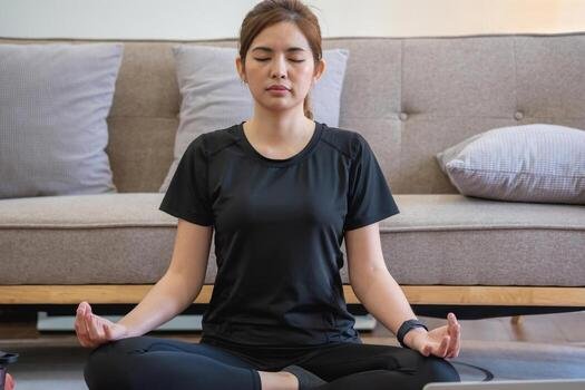 Woman seated in meditation pose practicing pranayama breathing techniques at home